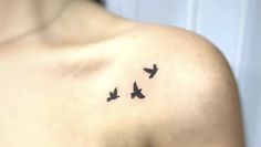 a woman's chest with three birds on it