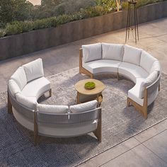 a white couch and chair sitting on top of a rug next to a wooden table