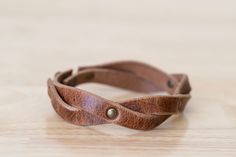 a close up of a leather bracelet on a table