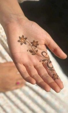 a woman's hand with a flower tattoo on it