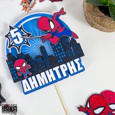 a spiderman themed birthday cake topper on a stick