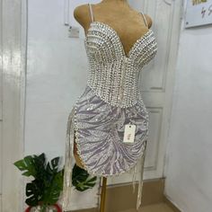 a mannequin wearing a dress made out of silver sequins and beads