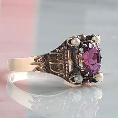 Details: Beautiful Victorian Garnet and Seed Pearl ring set in lovely 14K rose gold. The band is adorned in lovely abstract filigree engraving. The stone has great depth, and has a lovely rich pink tint to the garnet. It is surrounded by 4 seed pearls. The garnet measures 7.5mm x 5mm. There are no internal markings. Measurements: Ring measures a size 7 3/4 US. It can be re-sized for a fee. Condition: The overall all condition of this ring is very good. Please ask all questions prior to placing a Antique 14k Rose Gold Rings, Victorian Rose Gold Ruby Ring, Classic Pink 14k Rose Gold Jewelry, Victorian Rose Gold Ruby Ring For Anniversary, Vintage 14k Rose Gold Rings, Antique Rose Gold Promise Ring, Victorian Rose Gold Promise Ring, Pink Rings With Intricate Design For Anniversary, Heirloom Style Pink Birthstone Rings