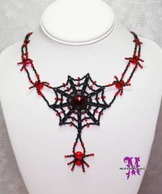 a black and red beaded necklace on a white mannequin