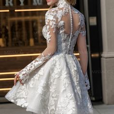 a woman in a short white dress is walking down the street