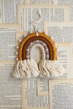 an ornament made out of wood and tassels on top of books