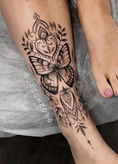 a woman's foot with a butterfly tattoo on the top and bottom of it