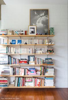 a bookshelf filled with lots of books on top of a hard wood floor