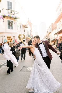 a newly married couple walking down the street with confetti and streamers in hand