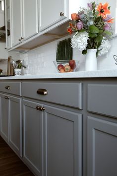 a vase filled with flowers sitting on top of a kitchen counter