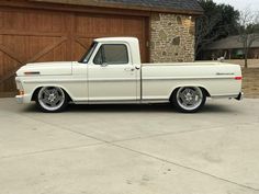 a white pickup truck parked in front of a garage