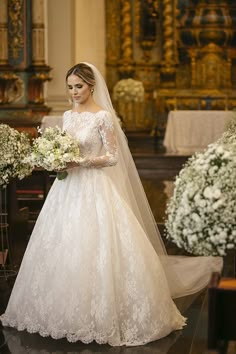 the bride is walking down the aisle with her bouquet in hand and she is wearing a wedding dress