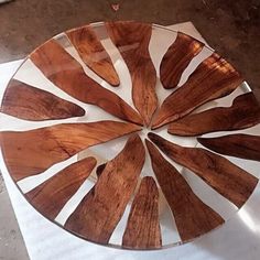 a glass plate with wooden spoons arranged in a circle on top of a table