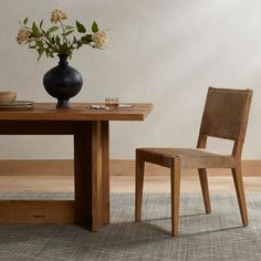 a table with two chairs and a vase on it