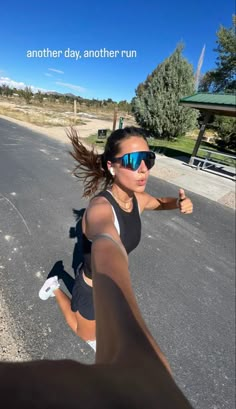 a woman running down the street with sunglasses on