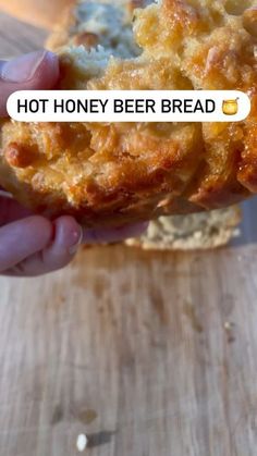 a person holding up a piece of bread with cheese on it that says hot honey beer bread