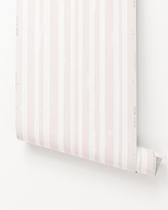 a pink and white striped wallpaper with vertical stripes on it's side, hanging from the wall