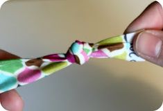 a hand holding a small colorful bow tie