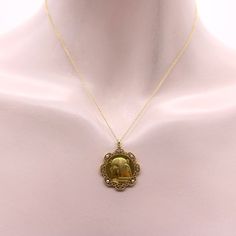 This is part of Chairish’s Fine Jewelry assortment.  This 18k gold two-sided French Victorian Egyptian Revival pendant necklace features the portrait of the goddess Nekhbet, surrounded by a lace-like halo of pearls and Rose Cut diamonds. Circa the 1880’s, the portrait is exquisite and the detail is crisp and impeccable, despite the age of the piece. The back of the medallion has a circle of hieroglyphics that include a bird, crow, sphinx, and other intricate shapes. The lacy border is lovely, wi Antique Yellow Gold Medallion Pendant Necklace, Antique Style Yellow Gold Medallion Pendant Necklace, Luxury Gold Medallion Pendant Necklace, Luxury Gold Medallion Locket Necklace, Luxury Gold Medallion Necklace, Yellow Gold Medallion Locket Necklace In Amulet Style, Gold Brass Amulet Locket Necklace, Luxury Gold Cameo Jewelry, Antique Yellow Gold Medallion Necklace