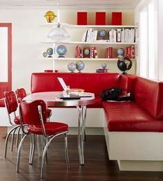 a red and white room with a table, chairs, bookshelf and shelves