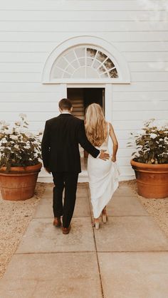 a bride and groom walking into the church