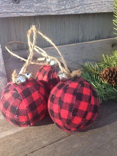 two red and black plaid christmas ornaments on a wooden bench