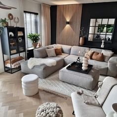 a living room filled with lots of furniture next to a tall window covered in curtains