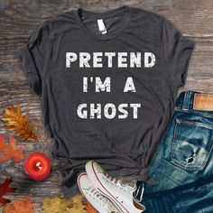 a t - shirt that says pretend i'm a ghost next to some autumn leaves