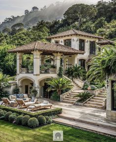 a large house with lots of trees and bushes around the front yard, surrounded by lush greenery