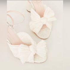 a pair of white shoes with bows on them