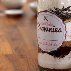 a glass jar filled with brownies on top of a wooden table covered in dirt