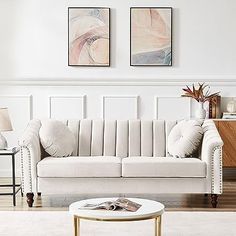 a living room with two paintings on the wall and a couch in front of it