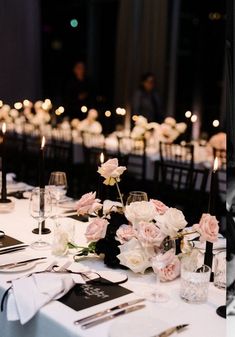 the table is set with flowers, candles and menus for an elegant wedding reception