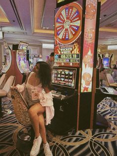 a woman sitting on a chair in front of slot machines