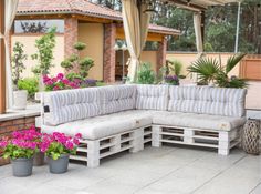 a couch made out of pallets sitting on top of a patio