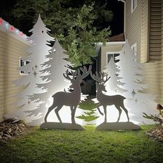 an outdoor christmas decoration with deer and trees