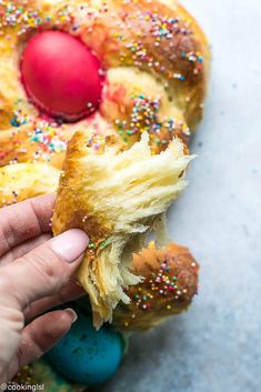 a person holding a piece of bread with sprinkles on it and an egg in the middle