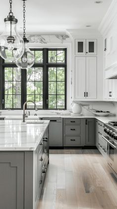 a large kitchen with white cabinets and marble counter tops, along with an island in the middle