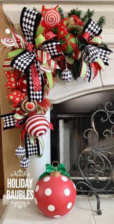 a christmas wreath on top of a fireplace next to a red ball and green bow