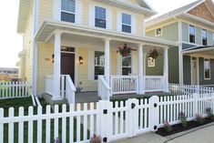 two houses with white picket fence in front of them