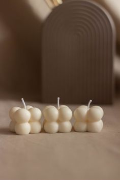 three small white candles sitting on top of a table