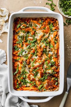 a casserole dish filled with meat, cheese and spinach on a table