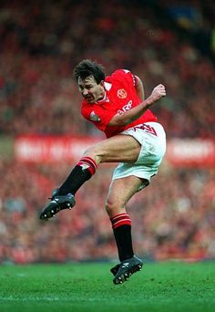 a man kicking a soccer ball on top of a field