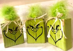 three wooden boxes with green decorations on them and some grass in the top one is heart