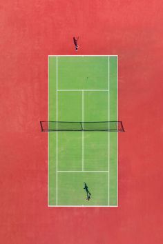 two people are playing tennis on a red and green court with one person jumping up to hit the ball