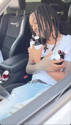 two people sitting in the back seat of a car, one with dreadlocks