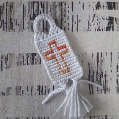 a small white bag with an orange cross on it