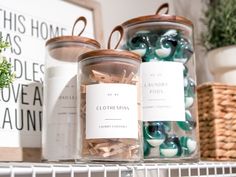 two jars with labels on them sitting on a shelf next to plants and other items