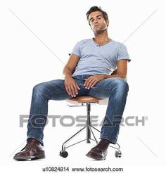 a man sitting on top of a chair with his legs crossed, looking up at the camera