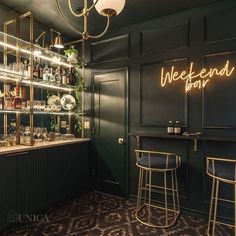 a dimly lit bar with two stools in front of it